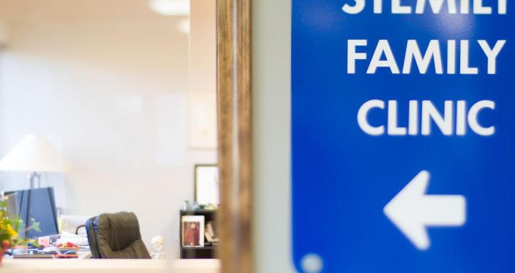 View of the entrance to a dr. waiting room with a blue sign next to door that reads Stemilt Family Clinic