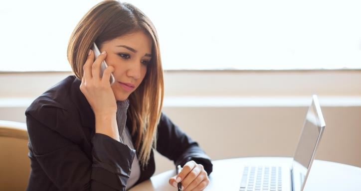 woman on the phone going over deal with someone on the other end of the line.