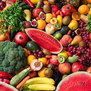 A colorful assortment of fruits and vegetables, featuring watermelon, bananas, pears, avocados, and broccoli.